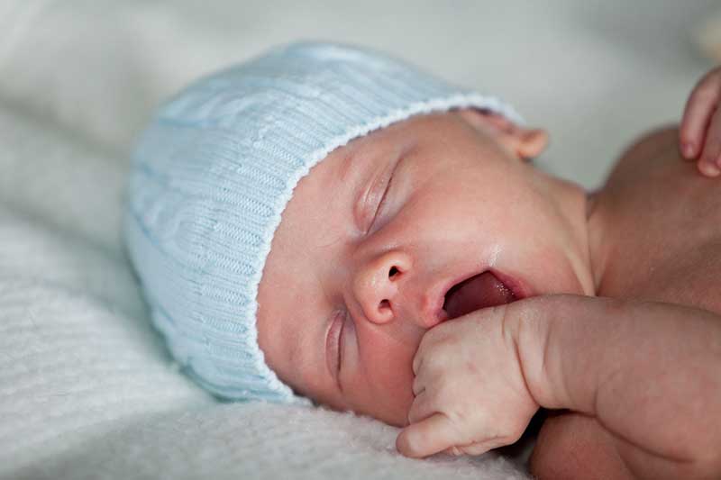 Baby touching his face