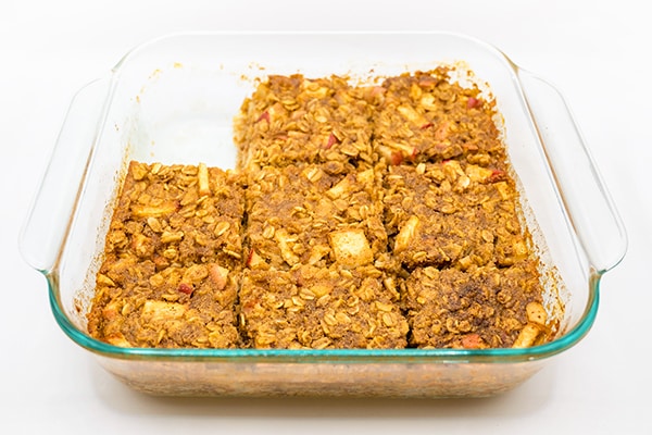 Photograph of the apple cinnamon baked oatmeal recipe with one square cut ut of the pan