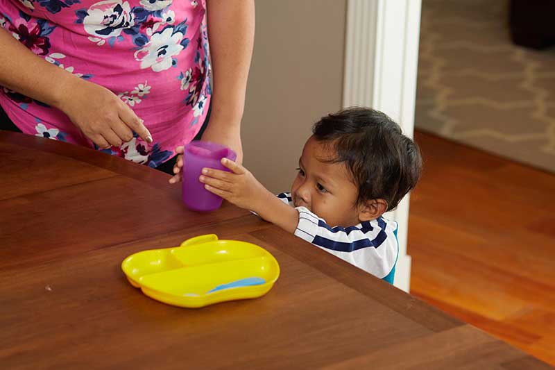 toddler helping set table