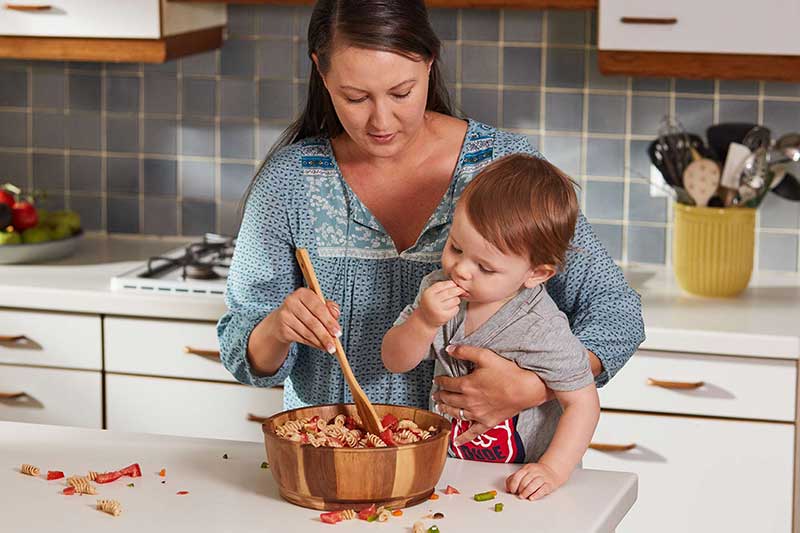 self-feeding toddler helping stir