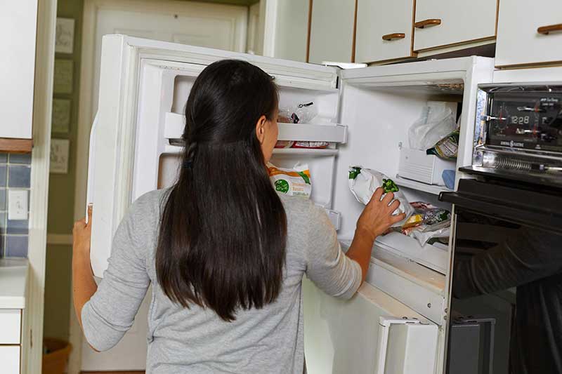 mom getting frozen veggies out of freezer