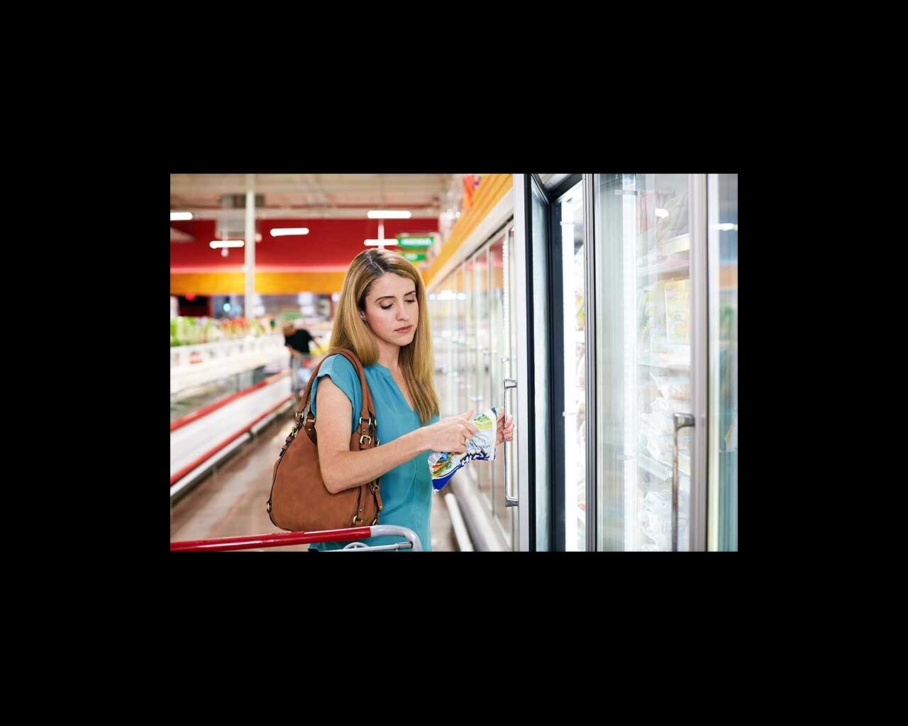 mom looking at frozen food in grocery store