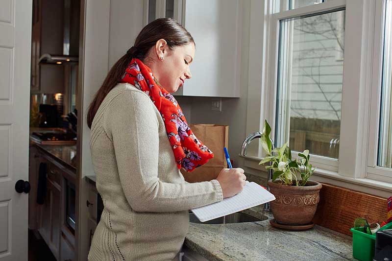 mom writing in journal in kitchen