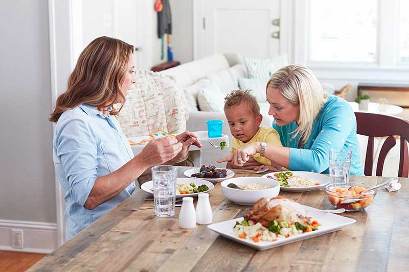 Dos mujeres alimentando a un niño pequeño