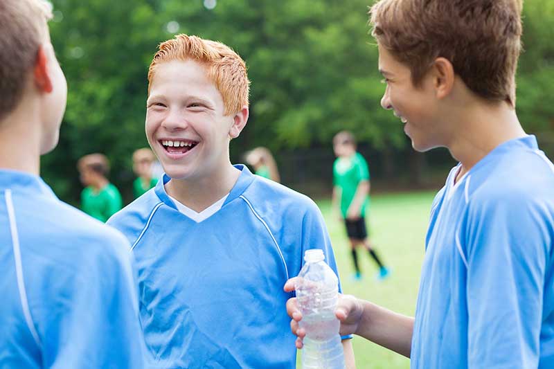 boys on a soccer field drinking water