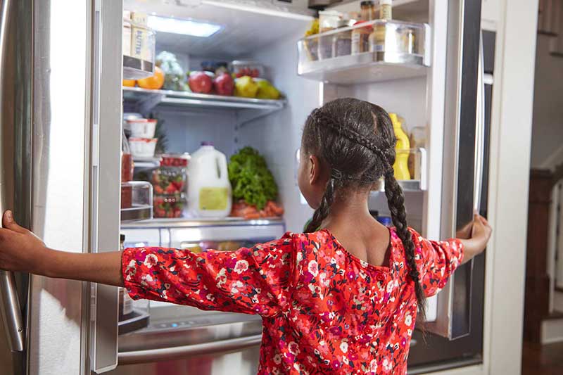 girl opening fridge