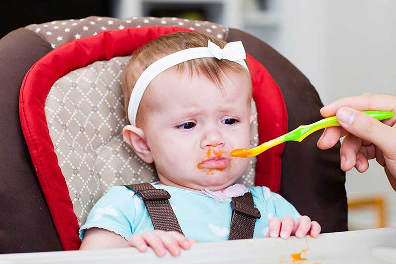 Bebé cerrando la boca a la comida o alimentación