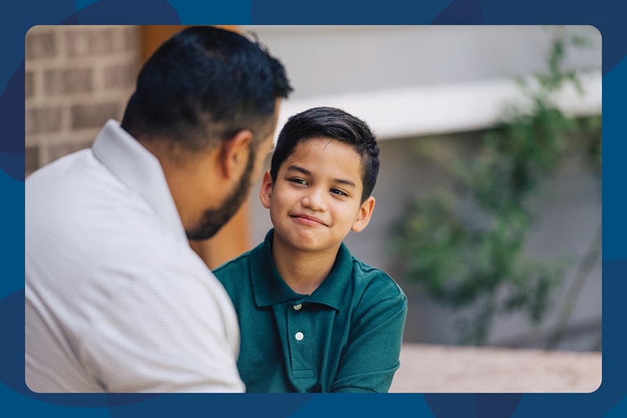 Dad talking to elementary age son on front porch