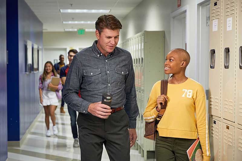 student and teacher talking at school