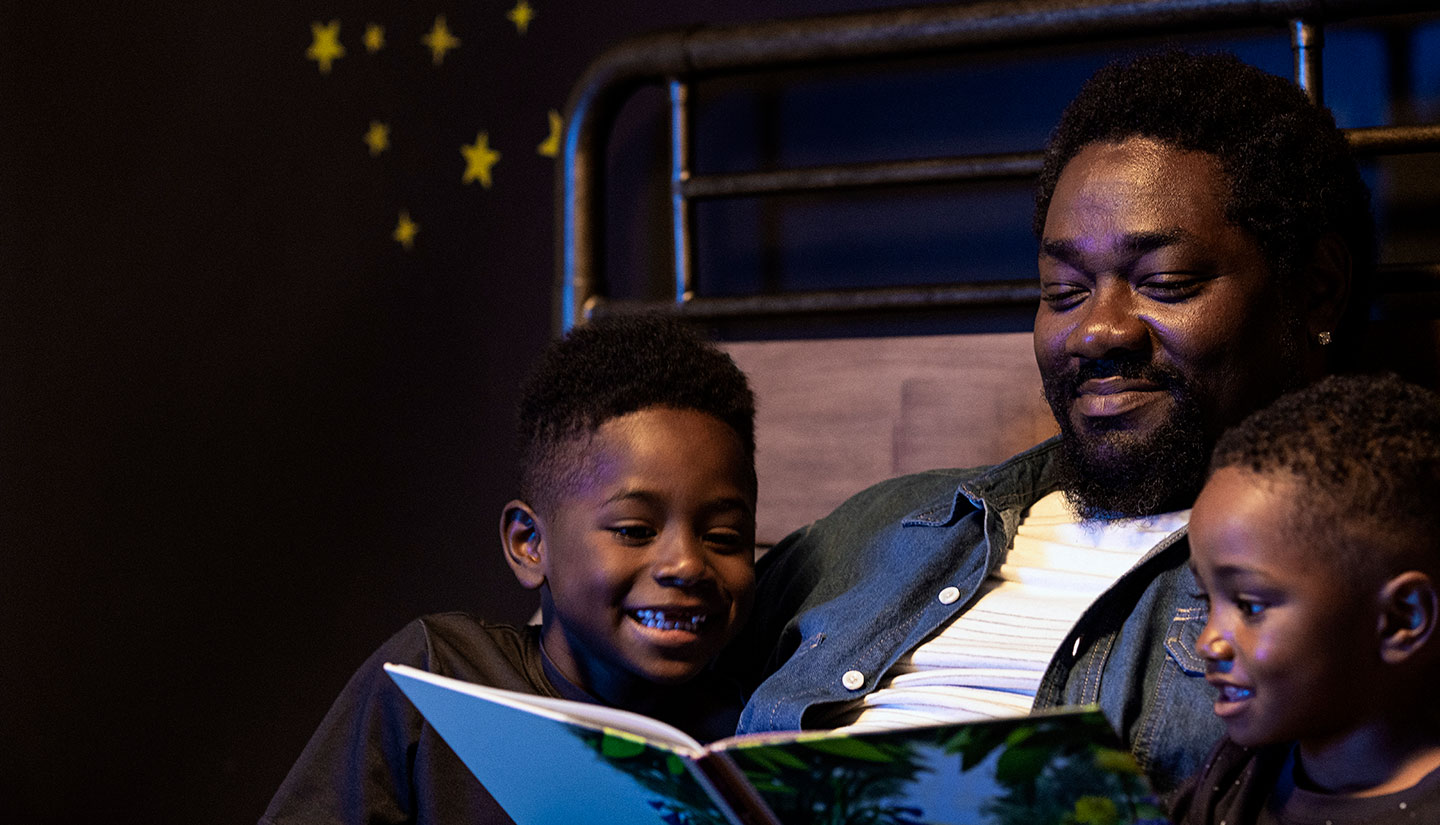 Father reading to sons in bed