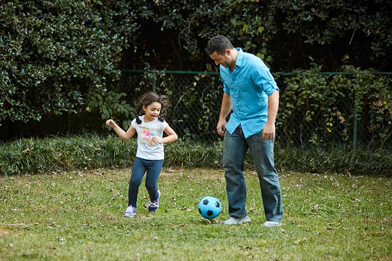 dad and daughter playing soccer