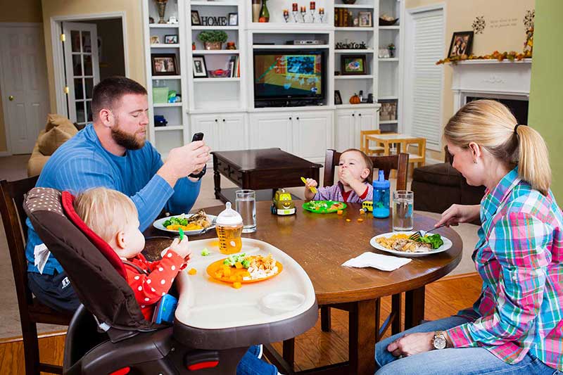 family eating dinner using phones