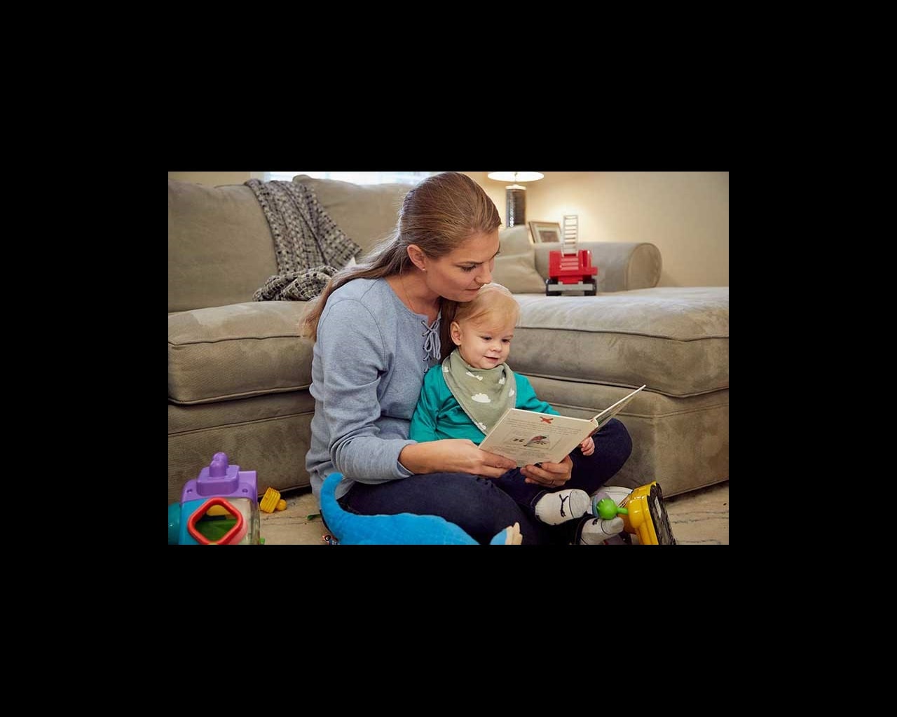 White mom reading a book to her infant son