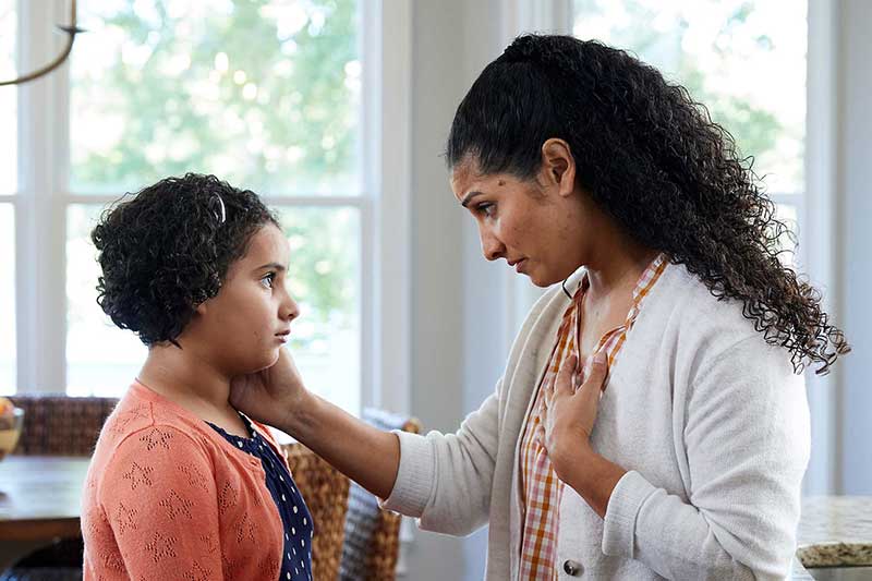 Mom compassionately speaking to daughter