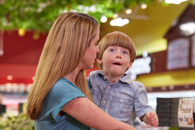 Young boy innocently saying something inappropriate at the grocery store