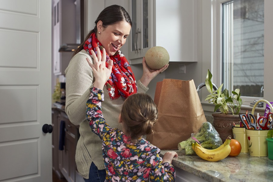 mom and daughter high fiving in kitchen