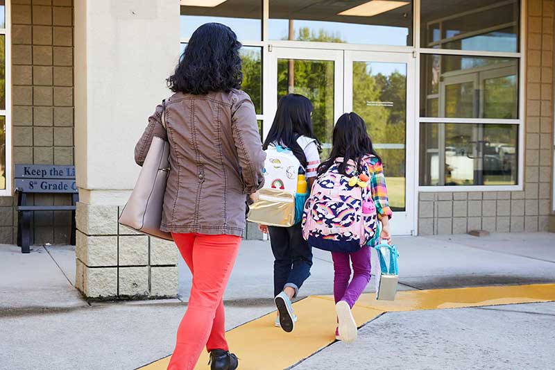 mom walking daughters to school