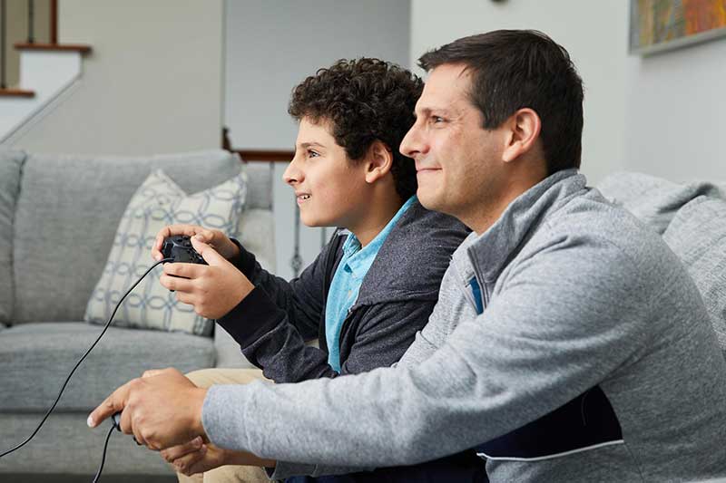 dad and son playing video game together