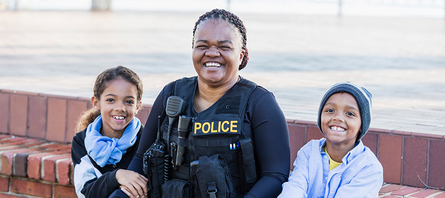 Police officer sitting with two smiling kids
