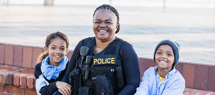 Police officer sitting with two smiling kids