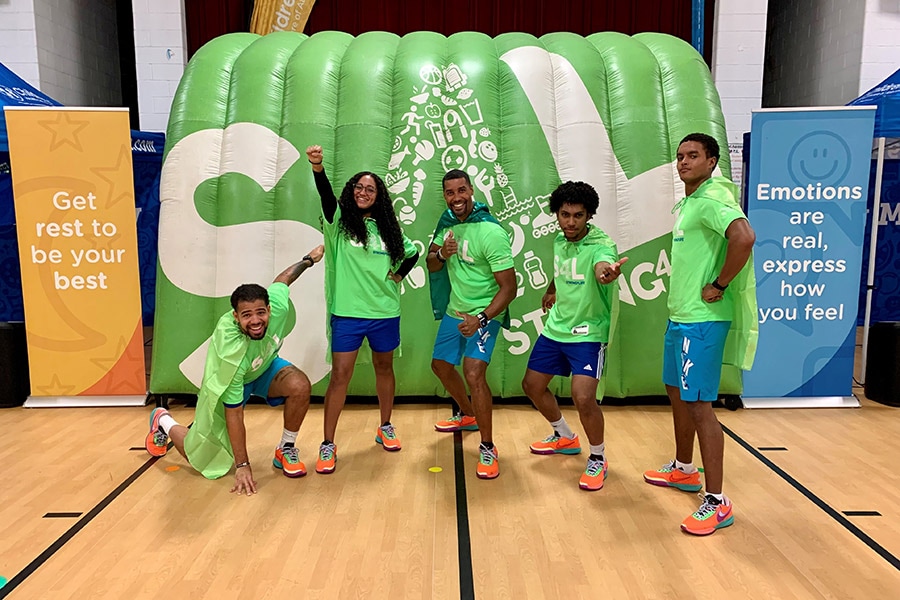 Members of the Strong4Life Challenge Team posing is capes in an elementary school gym