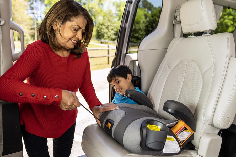 Grandmother installing low-back booster seat