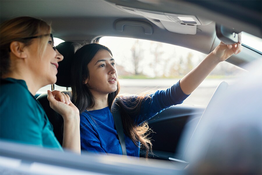 mom giving daughter driving lessons