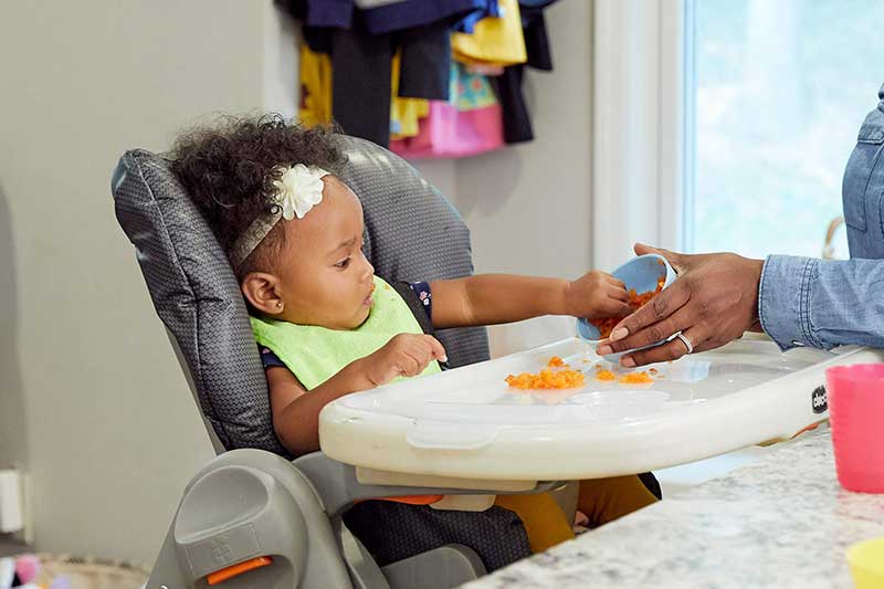 infant eating mashed veggies