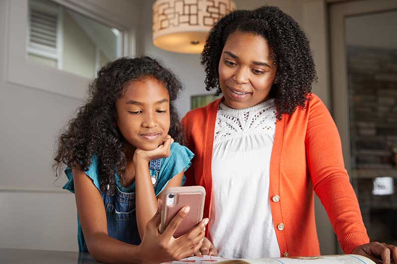 young girl on phone with mom