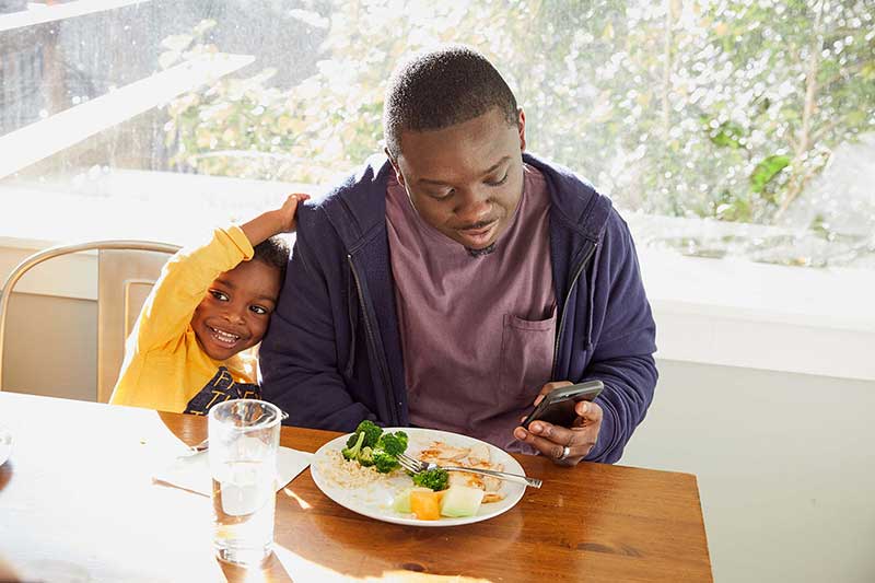 dad on phone at dinner table