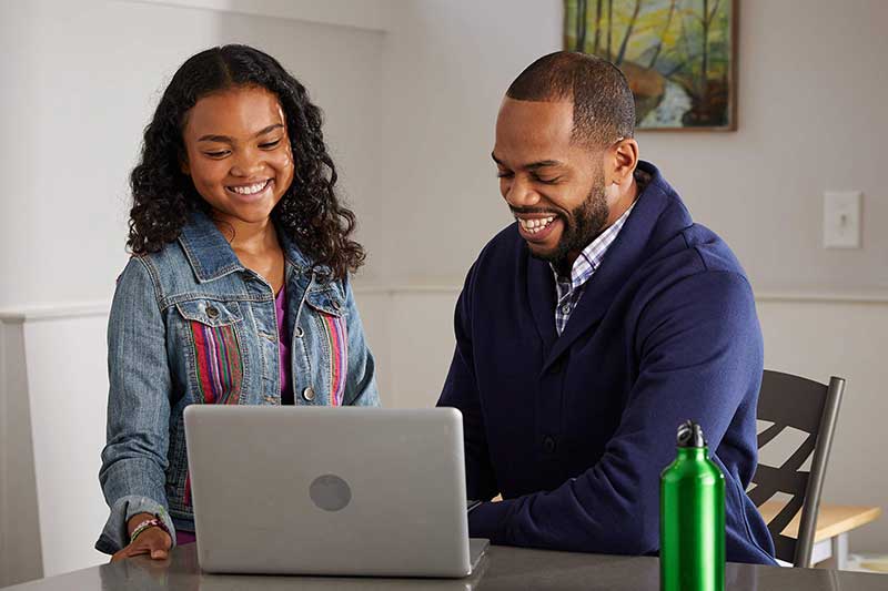 dad and daughter using laptop