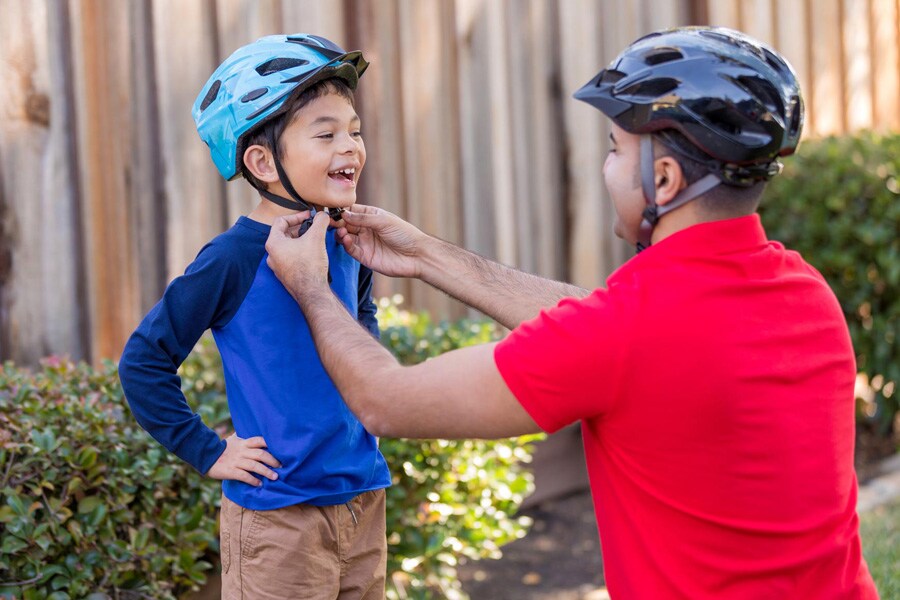 dad adjusting son's helmet