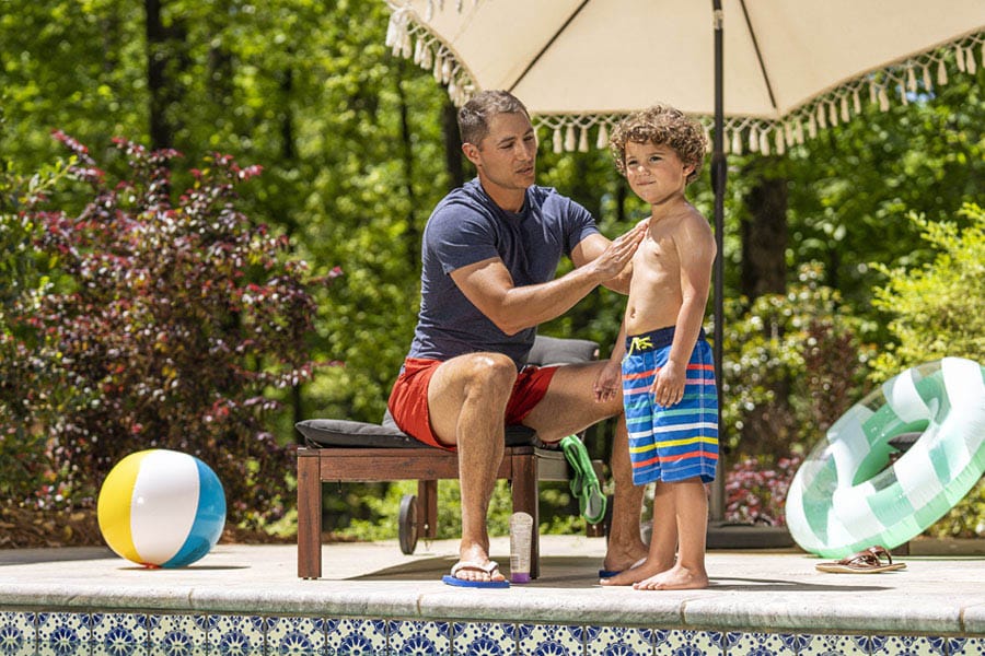 dad putting sunscreen on son