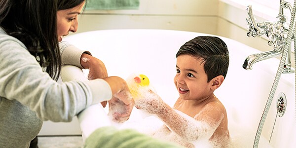 Mom stays within arm’s reach of toddler during bath time.