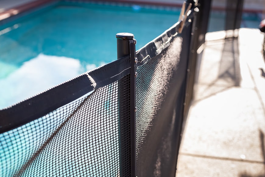 An image showing a pool fence around the perimeter of a swimming pool.