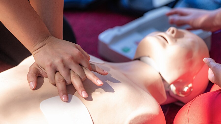 A photo of someone practicing chest compressions on a CPR dummy.