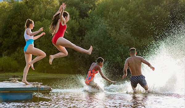 A photo of teens jumping into open water at the lake.