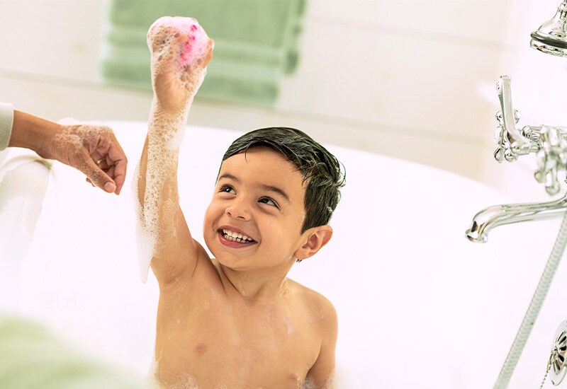 Mom using touch supervision with toddler boy in bath