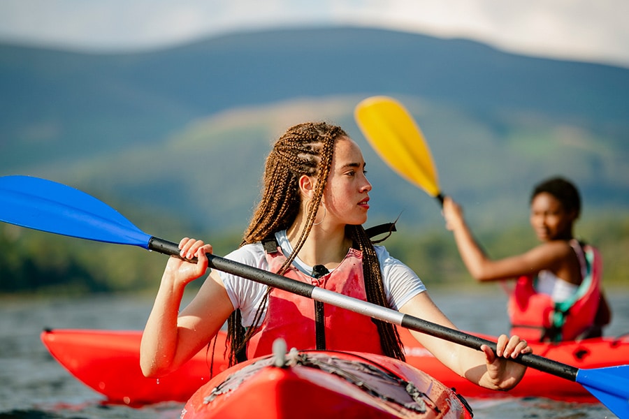 Teen kayaking while wearing a life jacket for safety