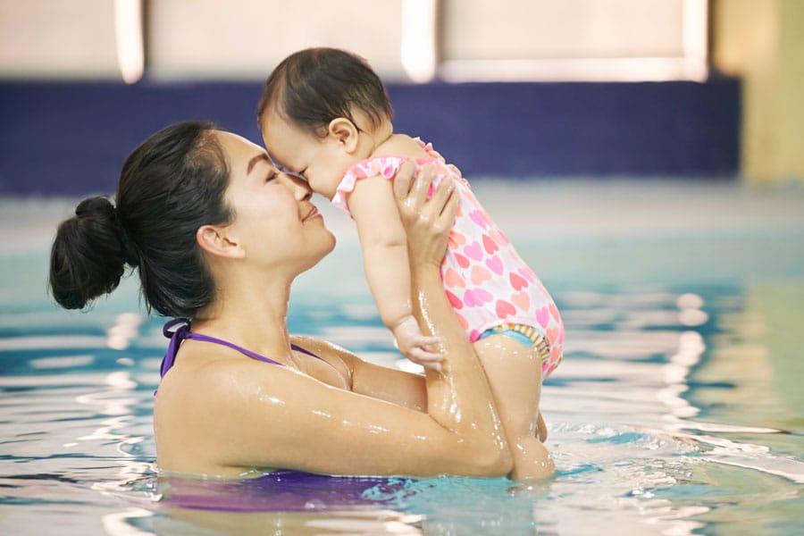 Mom uses touch supervision with baby in the pool to practice water safety and drowning prevention.