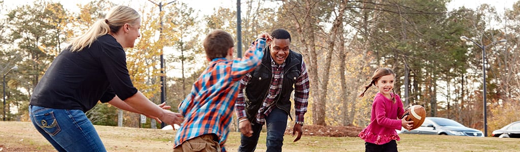 family playing football in park
