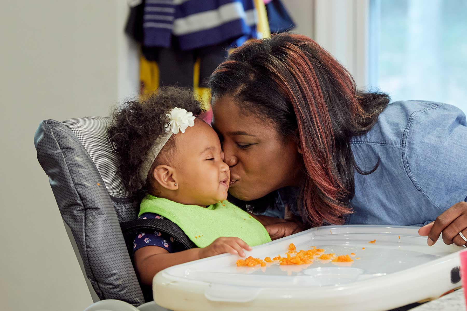 mom giving baby a kiss while eating