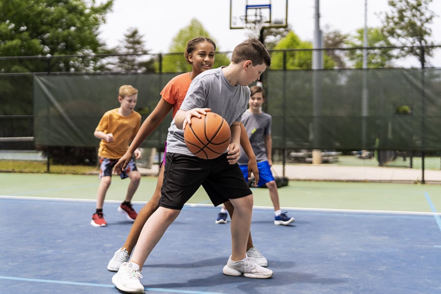 school age kids playing basketball
