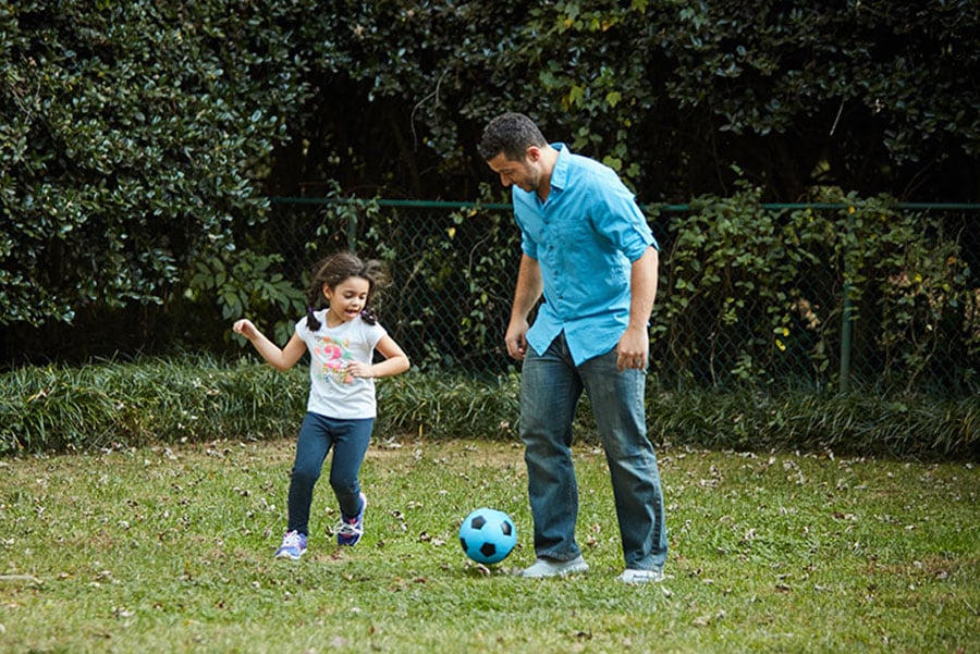 dad and daughter playing soccer