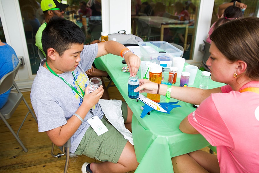 Child making a glitter jar at camp