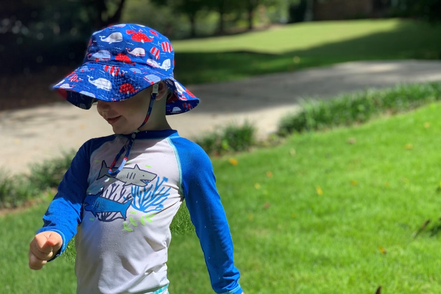 toddler wearing hat and long sleeves outside